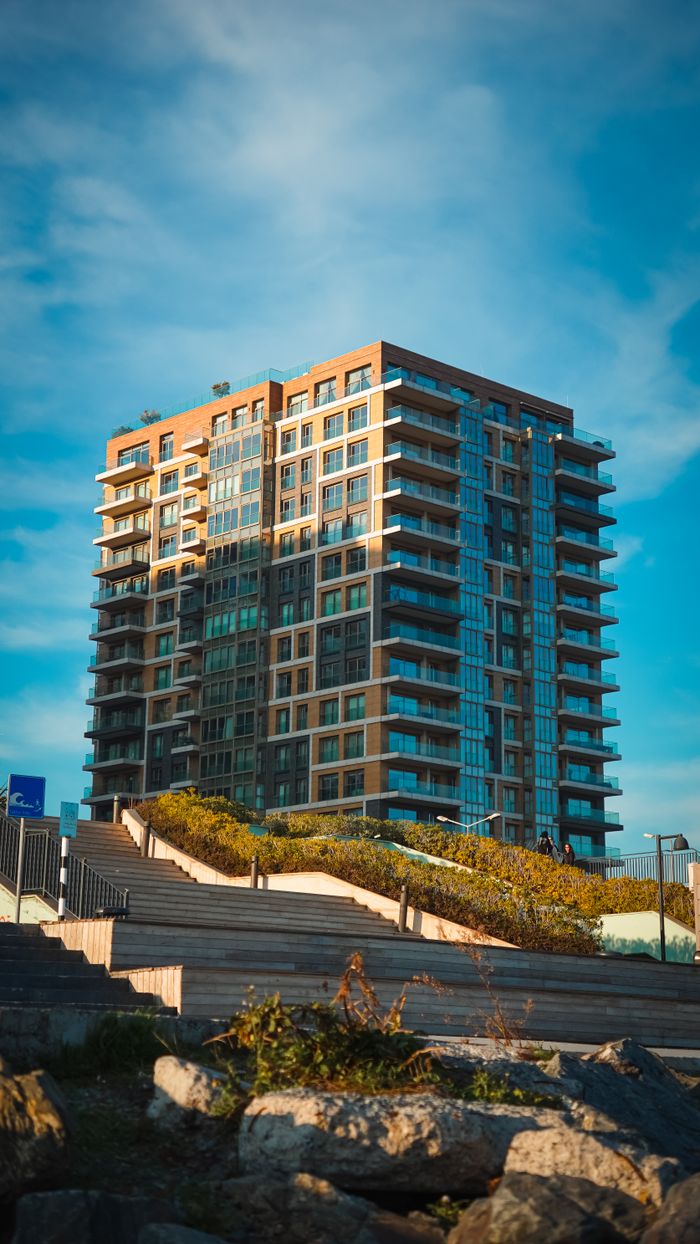 contact-img Contemporary high-rise building in Istanbul, under a bright blue sky.