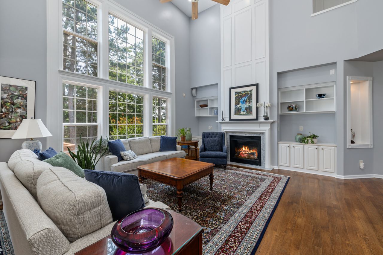ours-journey Bright living room with large windows, fireplace, and elegant decor.